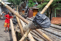 Aep, 50, shaves bamboo for panjat pinang (pole climbing) competitions, which are usually held during Indonesia’s Independence Day celebrations, in Manggarai, Jakarta, on Aug. 13. Pinang bamboo craftsmen have seen a loss in income after the Jakarta administration restricted events that attract crowds amid the surge in COVID-19 cases. While in normal years, a craftsman can sell up to 50 pinang, this year they haven't been able to sell any. 