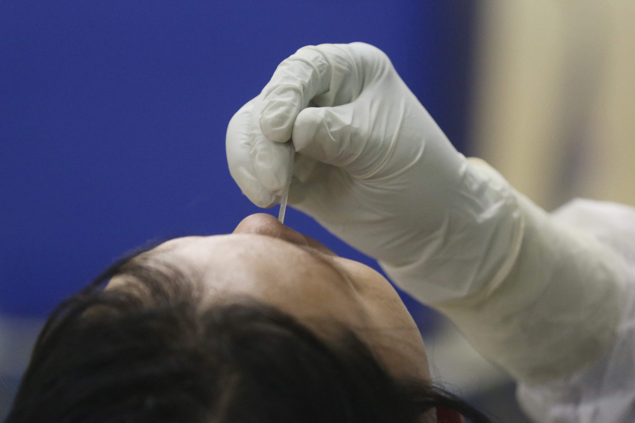 A health worker takes a nasopharyngeal swab from a journalist during a COVID-19 testing program on Nov. 4, 2020 at the Press Council in Jakarta.