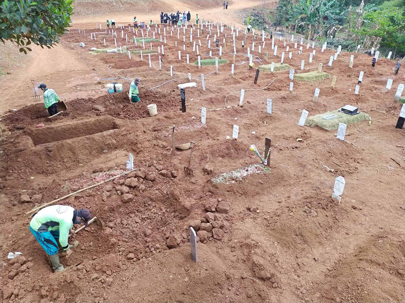 Grave situation: Diggers at the Pondok Ranggon cemetery in East Jakarta dig more graves for COVID-19 victims on Wednesday. The rate of COVID-19 funerals at Pondok Ranggon is still high with 700 to 720 funerals per month, and available plots are expected to run out in October.