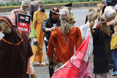 A protester sets up scarecrows during a protest against the omnibus bill on job creation in front of the legislative complex in Jakarta on Sept. 24, which coincides with National Farmers Day. The protesters voiced their opposition to the domestic food supply provisions in the omnibus bill, arguing that it could weaken domestic farmers’ production and favor importers. JP/Wendra Ajistyatama