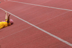 An asymptomatic COVID-19 patient rests on the ground following a round of morning physical exercises at the Patriot Candrabhaga Stadium isolation center in Bekasi, West Java, on October. 2. 2020. Physical exercise is deemed important to improve patients’ immune system against the coronavirus. JP/Dhoni Setiawan