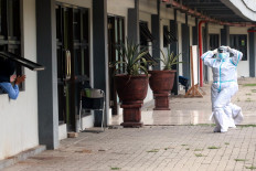A patient cheers on a medical worker leading morning exercises for asymptomatic COVID-19 patients undergoing isolation in the Patriot Candrabhaga Stadium in Bekasi, West Java, on October. 2. 2020. Medical workers monitor the patients’ conditions during their isolation. JP/Dhoni Setiawan