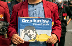 Severe migraine: A student protester holds up a poster based on the packaging design of a headache medicine on Thursday, October 8. 2020 during a demonstration on Jl. M.H. Thamrin in Central Jakarta. The poster reads: “The omnibus law causes headaches, environmental damage, workers’ oppression.” JP/Seto Wardhana