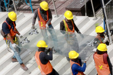 Workers carefully carry a glass plate at Jakarta’s oldest high-rise building, Sarinah, on Oct. 30. The iconic shopping center is undergoing a major renovation, costing Rp 700 billion (US$47.9 million). The project is expected to be completed on Aug. 17, 2021, coinciding with Sarinah’s 59th anniversary. JP/Dhoni Setiawan