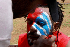 A Papuan Student Alliance (AMP) member has his face painted with the colors of the Bintang Kejora (Morning Star) flag during a protest on Jl. Medan Merdeka Barat, Central Jakarta, on Nov. 16. The protesters demanded that the government thoroughly investigate the killing of Papuan pastor Yeremia Zanambani in Intan Jaya, Papua, and withdraw military and police personnel from the country’s easternmost province. JP/Dhoni Setiawan