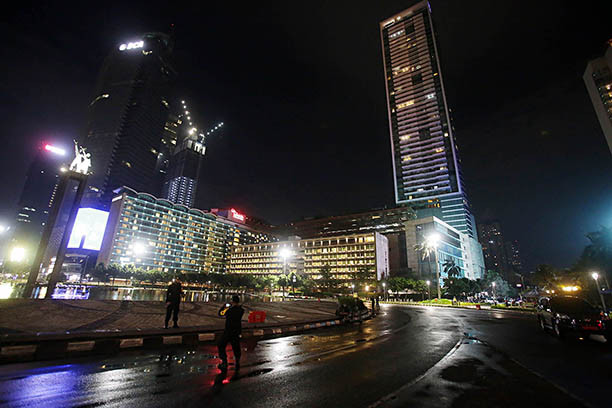 Oh so quiet: Visitors take a photo at a nearly deserted Hotel Indonesia (HI) traffic circle in Central Jakarta during an unusually quiet
New Year's Eve on Thursday, as the Jakarta administration imposed Car Free Night and Crowd Free Night to curb the spread of COVID-19.
