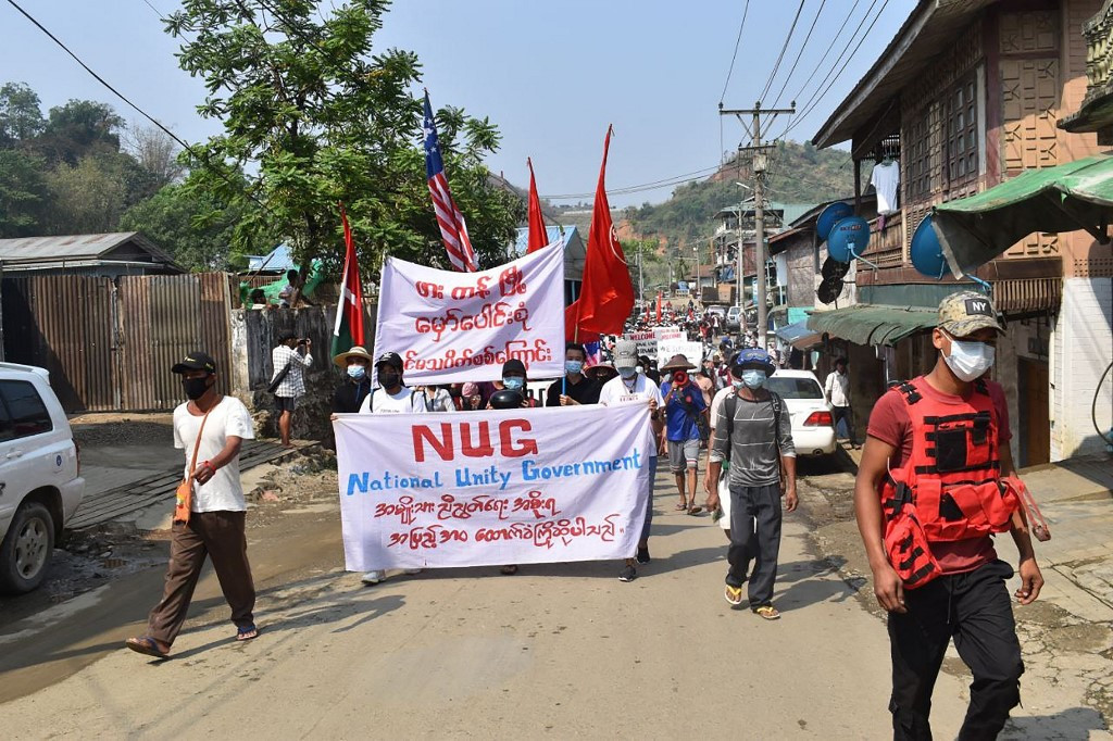 This handout from Kachinwaves taken and released on May 3, 2021 shows protesters holding a banner supporting the newly formed National Unity Government (NUG) as they march in a demonstration against the military coup in Hpakant in Myanmar's Kachin state. 